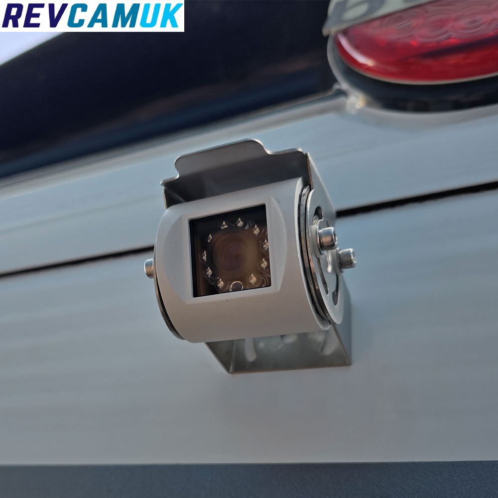 White rear-view or parking camera with adjustable lens angle, shown mounted on a polished stainless-steel bracket for secure installation
